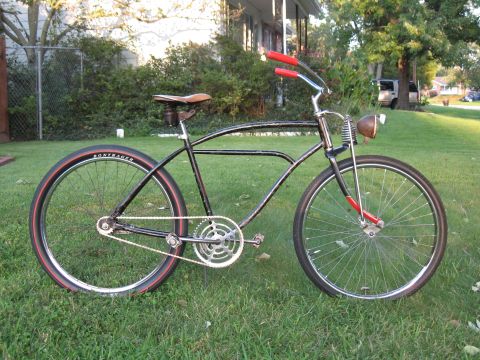 1994 Ford Bronco - A vintage black cruiser bicycle with red accents sits on a grassy lawn in front of a house.
