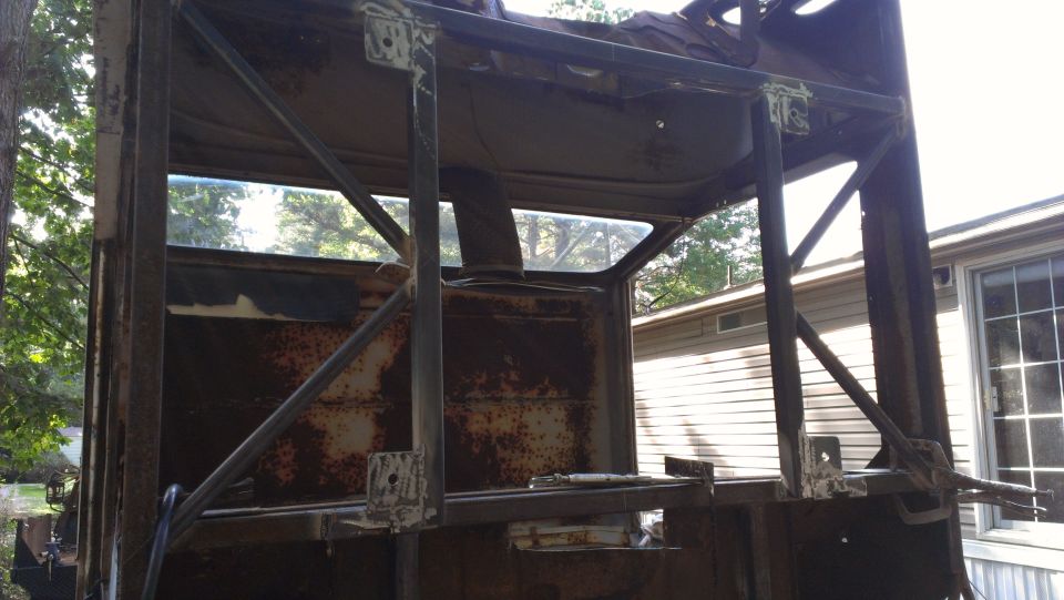 Rusted vehicle frame with roll cage, rear view