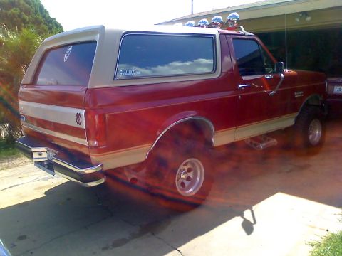 1990 Ford Bronco - This red and tan Ford Bronco features a two-tone paint scheme and auxiliary lighting on the roof.
