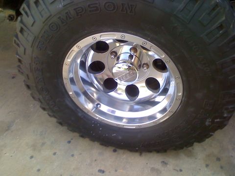 1990 Ford Bronco - Close-up of a vehicle's chrome wheel and tire, showing the brand 'THOMPSON' on the tire.