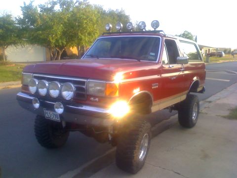 1990 Ford Bronco - This lifted red Ford Bronco is equipped with numerous auxiliary lights for off-road use.