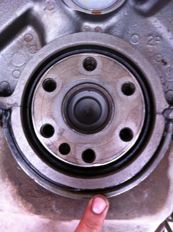 1990 Ford Bronco - Close-up of an engine crankshaft seal, with a finger indicating its placement. The 'SUPERMOTORS' logo is present.