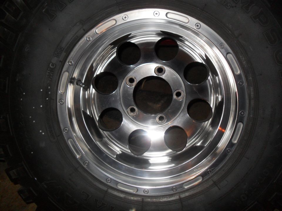 Chrome wheel with six circular cutouts and a black tire
