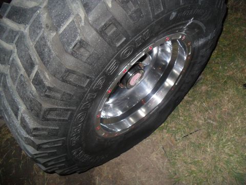 1990 Ford Bronco - Close-up of a vehicle's tire and rim, showing its tread and lug nuts.