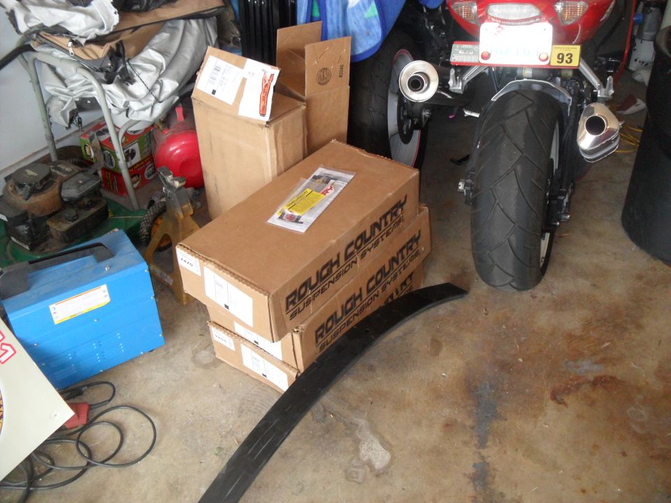 motorcycle rear end with boxes and tools in garage