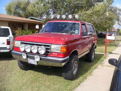 1990 Ford Bronco - This red Ford Bronco is equipped with multiple auxiliary lights on the roof and bumper.