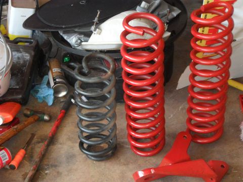 1990 Ford Bronco - Comparison of suspension springs, with red replacements next to a used black one.