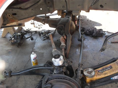 1990 Ford Bronco - Close-up view of disassembled vehicle suspension components and tools on a concrete surface.