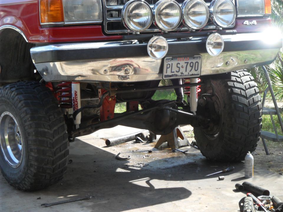 Red lifted truck front end with off-road tires, spotlights, and license plate PLS 790