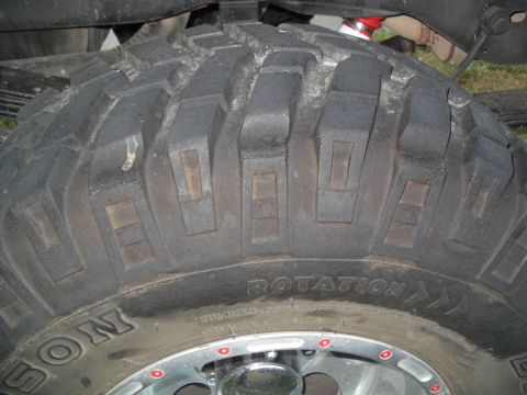 1990 Ford Bronco - A close-up view of a large off-road tire, showing its aggressive tread pattern and sidewall markings.