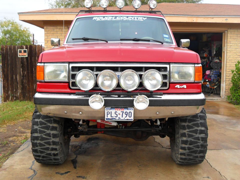 Red 4x4 SUV with roof lights and front light bar. License plate says PLS 790