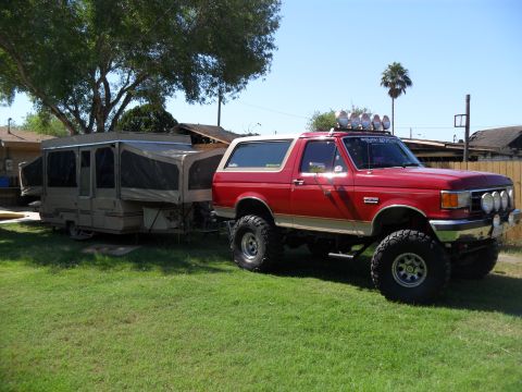 1990 Ford Bronco - This lifted 1990 Ford Bronco is equipped with auxiliary lights and tows a pop-up camper.