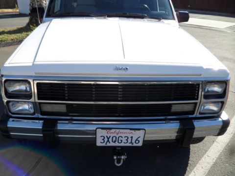 1994 Jeep Cherokee - Front view of a white 1994 Jeep Cherokee, showing its distinctive grille and headlights.