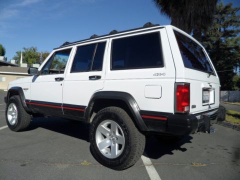 1994 Jeep Cherokee - Rear three-quarter view of a white 1994 Jeep Cherokee SUV parked in a lot.