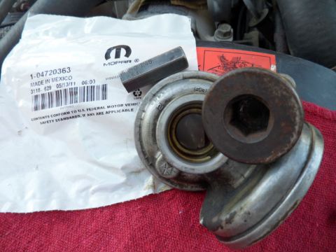 1994 Jeep Cherokee - A Mopar part, labeled 1-04720363, is shown with tools on a red cloth, likely for a vehicle repair.