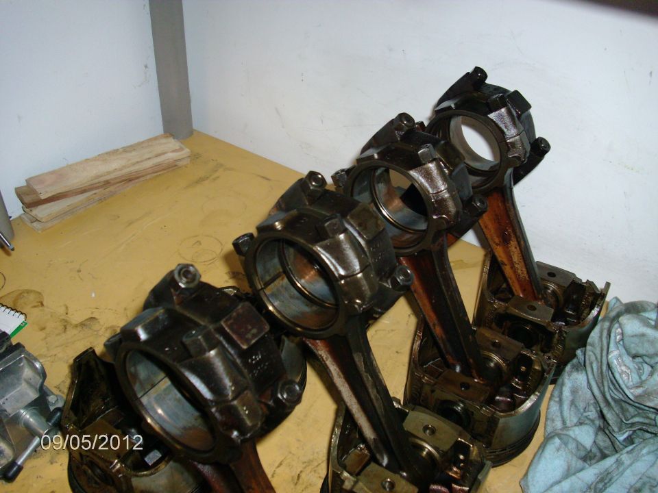 Engine pistons with connecting rods laid out on a workbench