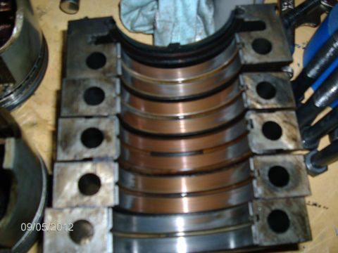 1979 Ford F-150 - Disassembled engine crankshaft main bearings with visible wear marks and a date stamp.