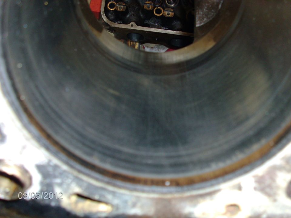 Inside view of an engine cylinder with some wear marks. Top of the cylinder head is visible