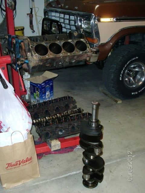 1979 Ford F-150 - Engine components from a 1979 Ford F-150 are laid out next to the partially disassembled truck.