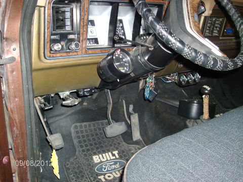 1979 Ford F-150 - The interior of a Ford F-150 features a "Built Ford Tough" floor mat and aftermarket gauges.