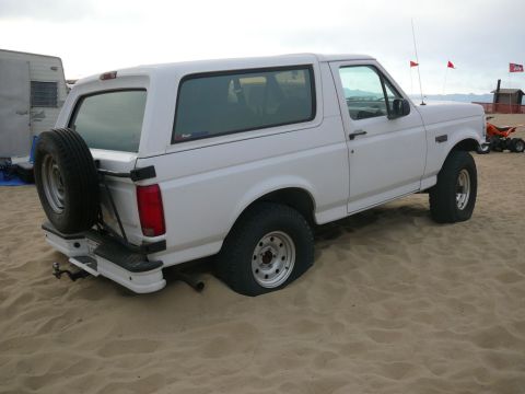 1988 Ford Bronco - This white Ford Bronco appears to be from the early 1990s, not 1988, and is stuck in the sand.