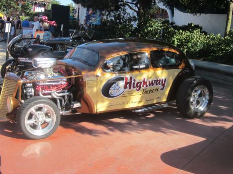 1991 Ford LTD Crown Victoria - A heavily modified Volkswagen Beetle, painted in brown and yellow, features a prominent V8 engine and custom graphics.