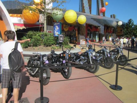 1991 Ford LTD Crown Victoria - A line of motorcycles is displayed in front of a building with distinctive architecture and large decorative spheres.