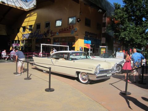 1991 Ford LTD Crown Victoria - A cream 1956 Lincoln Continental Mark II coupe is displayed in front of a building with 'Snacks' and 'Sports Bar' signs.