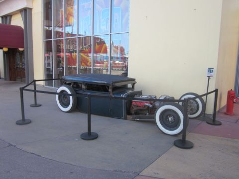 1991 Ford LTD Crown Victoria - A custom hot rod with a dark body and exposed engine is displayed outdoors.