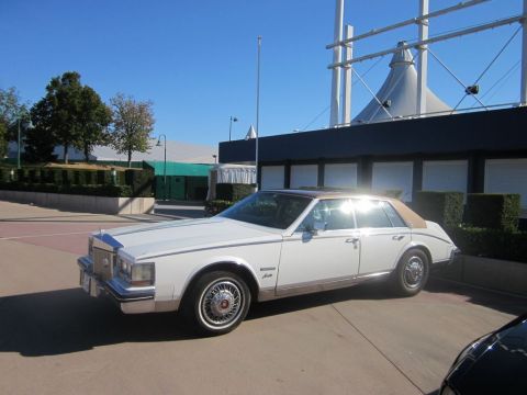 1991 Ford LTD Crown Victoria - A white sedan with a tan vinyl roof is parked outdoors on a sunny day.