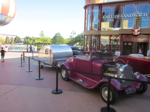 1991 Ford LTD Crown Victoria - A vintage roadster and trailer are displayed outside a restaurant.