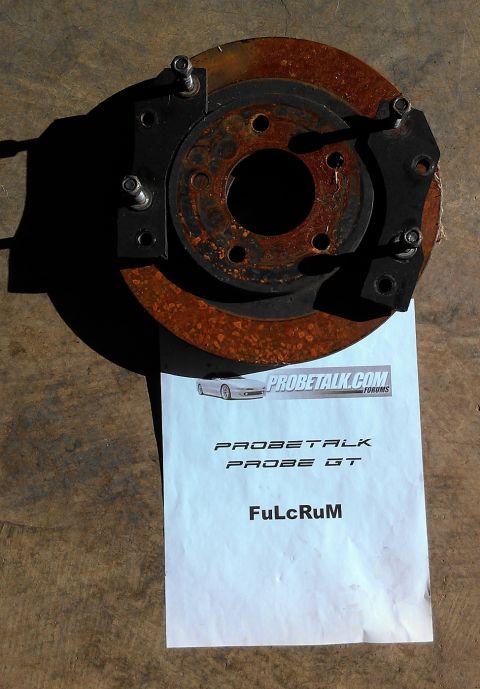 1995 Ford Probe - A rusty brake rotor and caliper assembly is shown on top of a document with Probetalk.com branding.