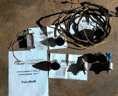 1995 Ford Probe - Various automotive parts, including gauges and wiring harnesses, are spread out on a textured surface.