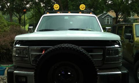 1994 Ford C-350 (Centurion Conversions) - This truck has a spare tire mounted on the hood and two smiley face lights on its roof rack.