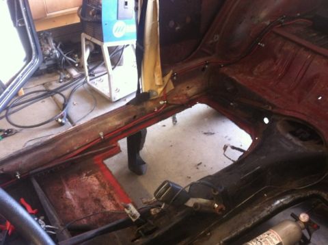 1970 Volkswagen Beetle - Rust repair in progress on a car's floor pan, with welding equipment visible.