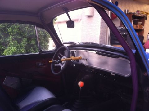 1970 Volkswagen Beetle - The interior of a custom Volkswagen Beetle features a yellow steering wheel lock and an orange shift knob, with a roll cage visible.