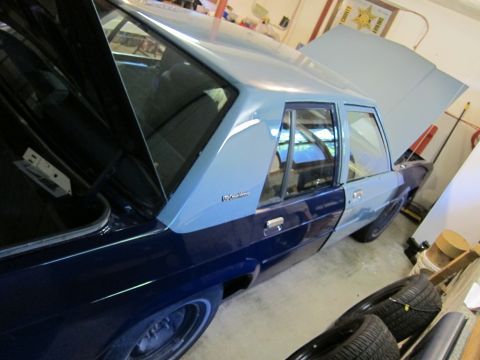 1991 Ford LTD Crown Victoria - A two-tone blue sedan with its hood and trunk open is parked inside a garage or workshop.