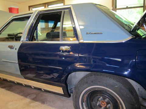 1991 Ford LTD Crown Victoria - The side of a 1991 Ford Crown Victoria LTD shows a two-tone paint job, with the front fender appearing to be a primer gray.