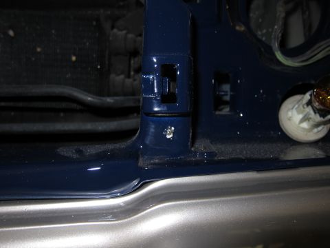 1991 Ford LTD Crown Victoria - Detail of a car's headlight mounting bracket, showing construction and paint.