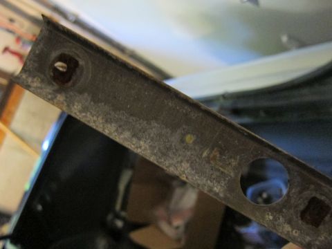 1991 Ford LTD Crown Victoria - A close-up view of a corroded metal trim piece, likely a car part, with visible rust and damage.