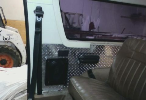 1986 Ford Bronco - The interior of a vehicle is visible, with a seat and diamond plate accents.
