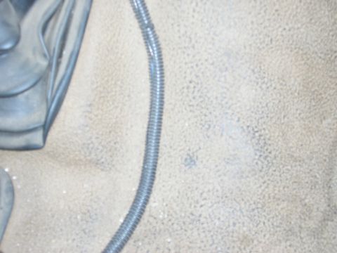 1986 Ford Bronco - Close-up of a vehicle's interior floor mat, showing a ribbed conduit running across it.