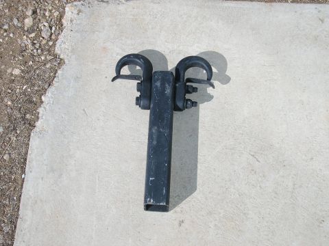 1986 Ford Bronco - A tow hitch receiver with two hooks is shown resting on a concrete surface.