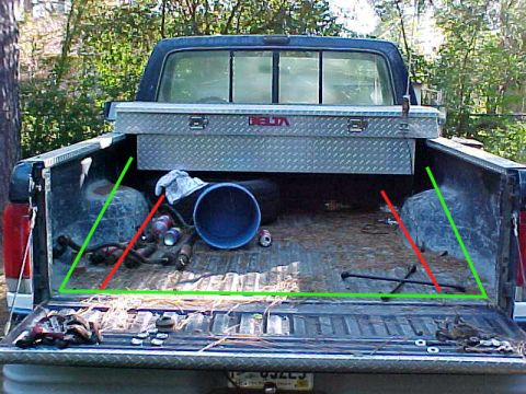 1989 Ford F-150 - The rear of a 1989 Ford F-150 pickup truck is shown, a diamond-plate toolbox and various items within the bed.