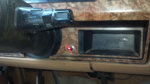 1986 Ford Bronco - Interior view of a vehicle dashboard, an aftermarket radio opening and a toggle switch.
