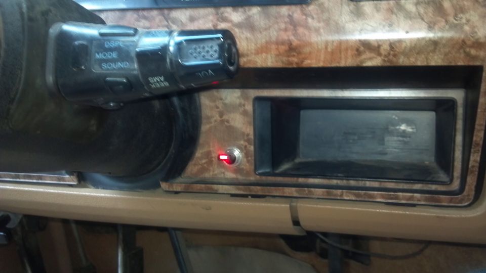 Dashboard interior showing an aftermarket radio slot and a toggle switch with a red LED. Controls on a stalk near the steering wheel have 'DSP', 'MODE', and 'SOUND' labels