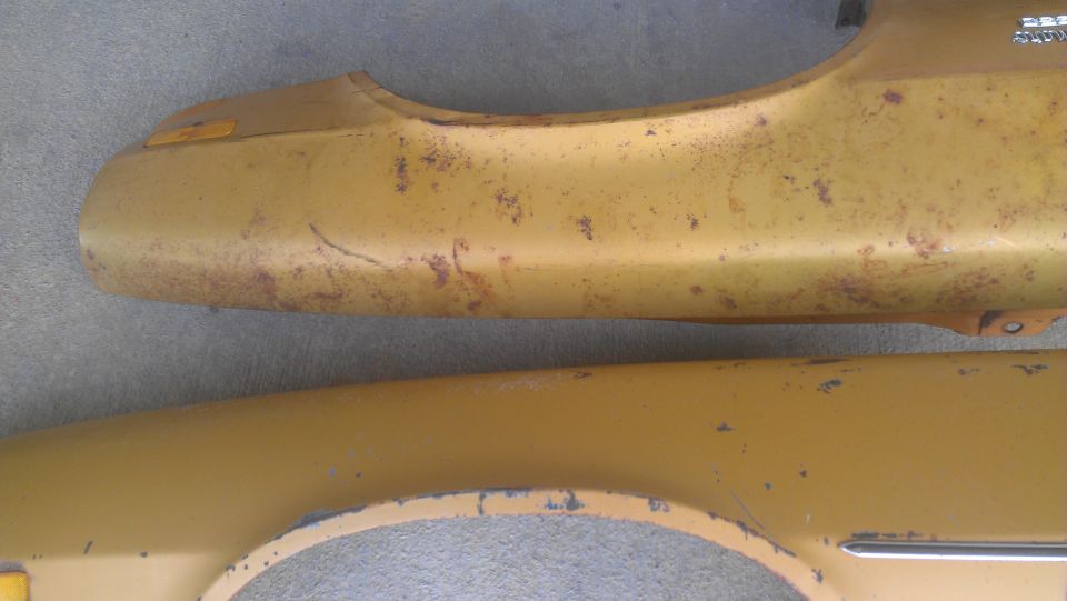 Yellow fender parts with rust and paint chips
