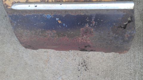 1973 Chevrolet Camaro - This heavily rusted car panel shows significant deterioration and damage.