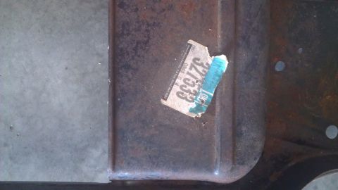 1973 Chevrolet Camaro - A close-up view of a rusted metal component with a partial sticker indicating a year and number.
