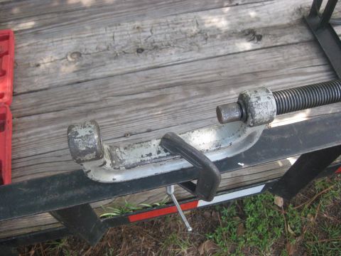 1994 Ford Bronco - A close-up view of a trailer jack mechanism, showing its threaded rod and clamp assembly.